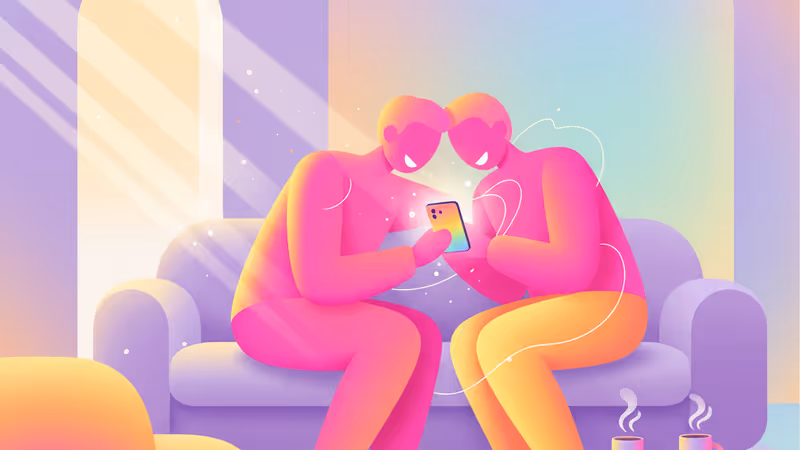 A couple laughing while looking at a smartphone together