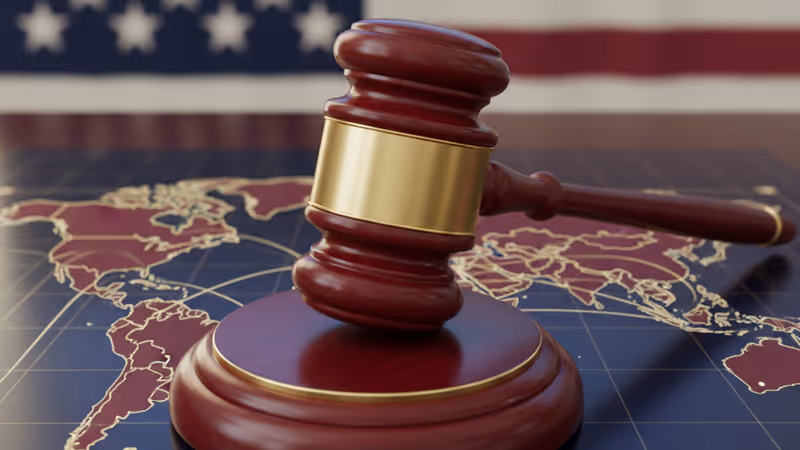 A legal gavel on a desk with a global trade map background